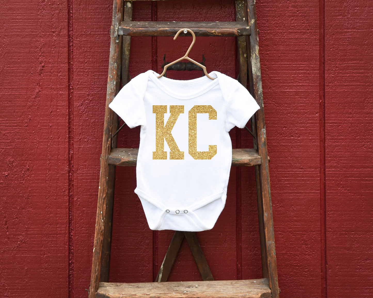 a wooden ladder with a baby's shirt hanging on it