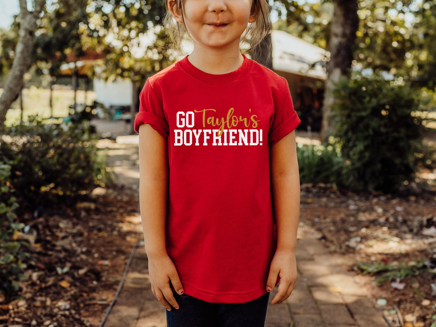 a girl wearing a red shirt that says go father's boyfriend