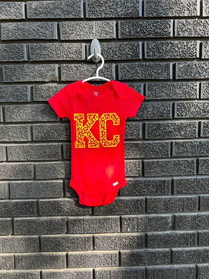 a red bodysuit hanging on a brick wall
