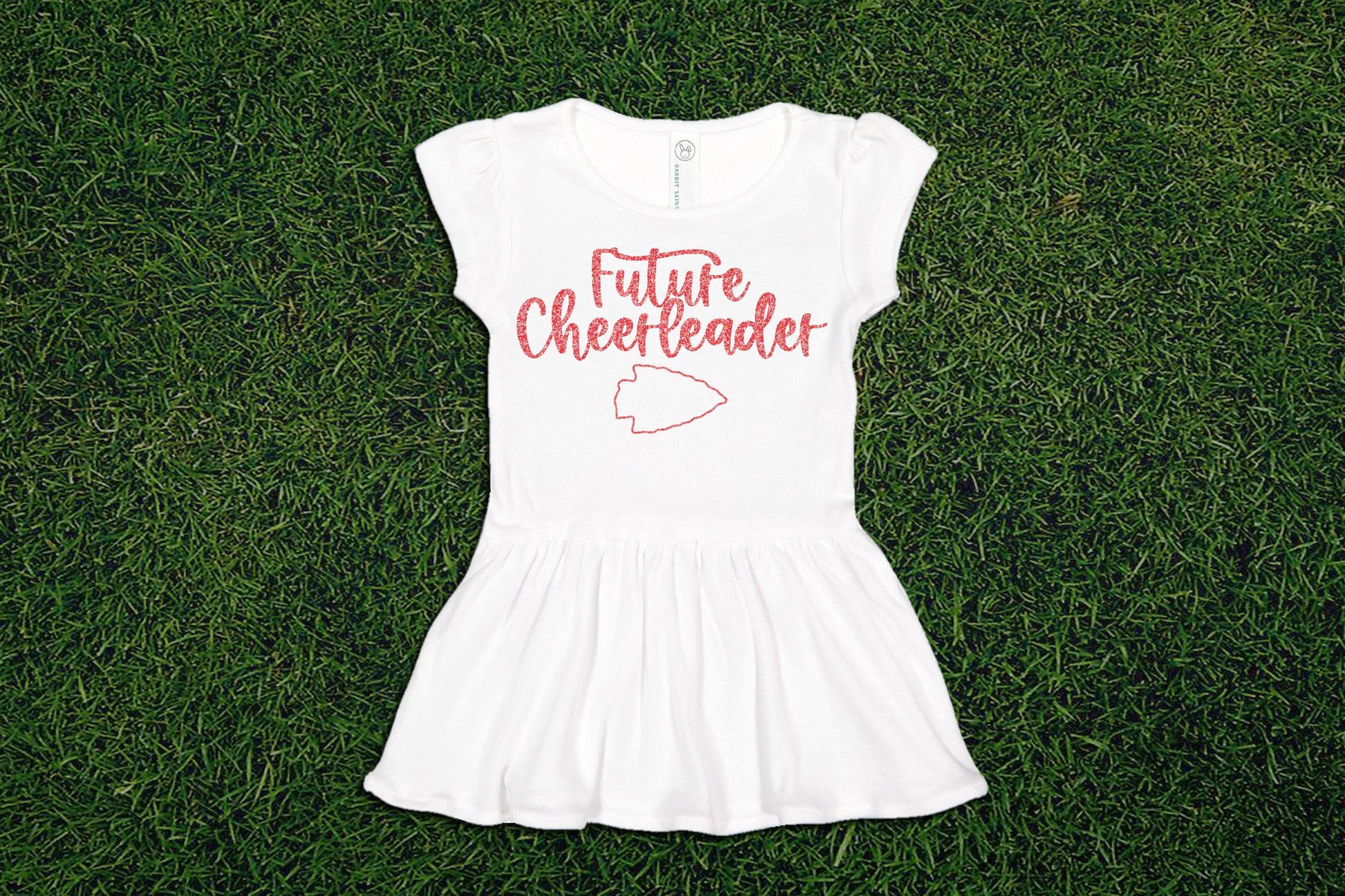 a white dress that says future cheerleader and an arrowhead on it