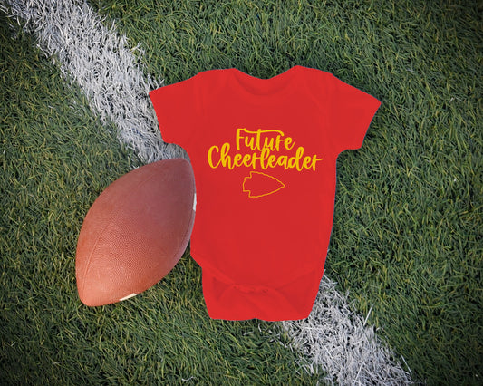 a baby bodysuit with the words future cheerleader next to a football on a field